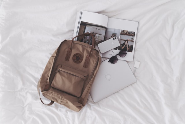 A backpack, book, phone, laptop, and glasses
